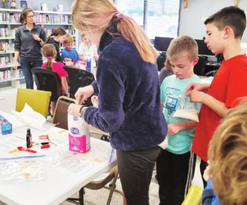 Magic Milk1: At the April 19th Mad Science Lesson in Oxford, Mrs. Elena Stout, Furnas/Harlan Extension Educator and students indulged in the chemistry of being food scientists by making ice cream. Photo courtesy of Oxford Library
